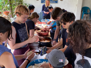 students cooking together with groups host families