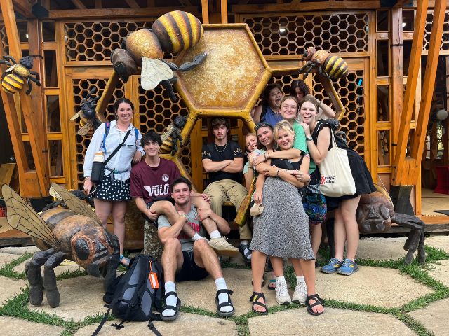 group of students posing together in front of bee