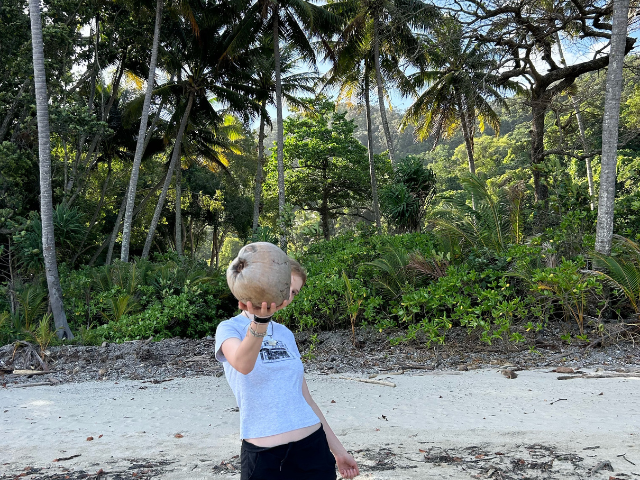 girl holding coconut on beach