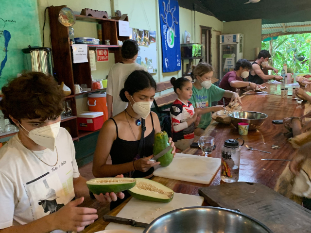students cooking and chopping cacao and vegetables