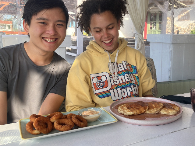 students preparing to eat pancake breakfast smiles