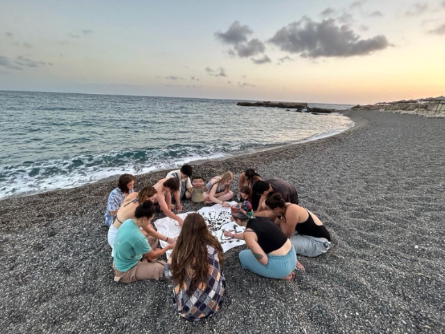 huddled over a project on the beach