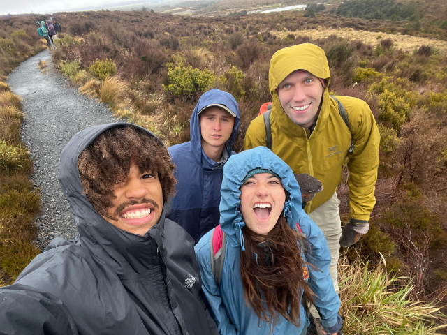 four friends in raincoats a the coast